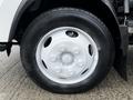 Close-up of a white wheel on a 2018 Isuzu NRR truck showcasing six lug nuts and a black tire with visible tread patterns