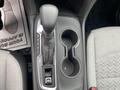 The center console of a 2022 Chevrolet Equinox featuring a gear shift lever cup holders and a textured surface