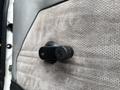 A close-up view of a door handle mechanism from a 1998 Freightliner FL80 in black plastic with a textured surface