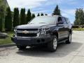 A 2017 Chevrolet Tahoe in black with a prominent front grille and chrome accents parked with a clear sky above
