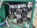 A close-up of the motor and control panel of a 2011 Hightliner Aquacide Hot Water Weed Control Dual Flat Deck Trailer with various pipes and components attached