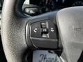 Close-up of the steering wheel of a 2022 Ford Transit featuring buttons for volume control and hands-free communication