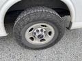 Close-up of the tire and wheel of a 2014 GMC Savana showing tread pattern and alloy rim design