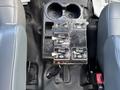 A control panel with several switches for a 2016 Ford F-750 located between two seats in the vehicle's interior.