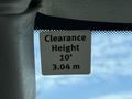 A sign displaying clearance height of 10 feet or 3.04 meters affixed to the interior of a vehicle