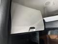 The interior of a 2022 Freightliner Cascadia showing a closed overhead storage compartment with a smooth white surface and a black handle