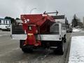 A 2008 Ford F-450 SD truck with a metal bed and a red salt spreader mounted on the back