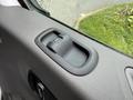 A close-up of the interior door handle of a 2022 Ford Transit with textured black plastic and a button for locking and unlocking the door