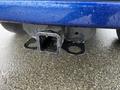 Close-up of a tow hitch receiver mounted on a blue 2019 RAM 1500 Classic with water droplets on its surface