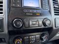 The interior dashboard of a 2020 Ford F-550 featuring audio control buttons and climate control settings