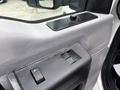 Interior view of a 2015 Ford F-350 SD's door panel showing window and lock controls along with a textured surfaces and a small knob