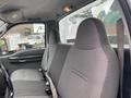 Interior of a 2003 Ford F-450 SD showing two grey cloth front seats with seat belts and a steering wheel partially visible