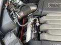 Close-up of a 2006 Audi A6 engine showing the air intake system and engine components with various hoses and fittings