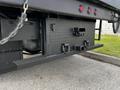 A utility compartment mounted on the rear of a 2021 Ford F-550 with a diamond plate design and multiple latches and hooks for secure storage