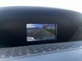 Display screen showing a rearview camera feed with guidelines for parking aligning with a road ahead