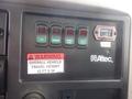 Control panel of a 2009 International 7400 with various buttons and a warning label indicating overall vehicle travel height