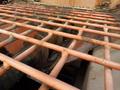 A close-up of a rusty metal grid with horizontal and vertical bars on a Freightliner M2 106 truck revealing mechanical components underneath