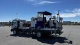 A 2006 Ford LCF 550 truck with a blue canopy and various equipment mounted in the truck bed for industrial use