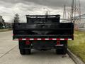 A black 2019 Ford F-550 truck viewed from the rear with a flatbed and a dual rear wheel configuration