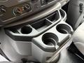 Center console of a 2022 Ford E-450 with two cup holders and various control knobs