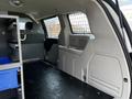 Interior view of a 2011 Dodge Grand Caravan showing a spacious cargo area with a partition and storage compartments