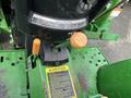 A close-up view of the controls on a 2003 John Deere 790 tractor including levers and a caution label