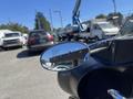 A 2004 Harley-Davidson Flhtcui motorcycle with chrome handlebars and a large rearview mirror reflecting the surrounding vehicles