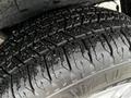 A close-up of a wet tire from a 2020 Ford Transit showing deep tread patterns and small debris embedded in the rubber surface