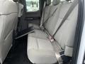 A 2017 Ford F-150 crew cab with a gray cloth rear bench seat featuring seatbelts and a fold-down center armrest