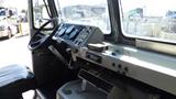 Interior view of a 2004 Freightliner MT45 with a large steering wheel gauges and controls on the dashboard