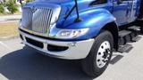 A blue 2012 International DuraStar 4300 truck with a chrome grille and large wheels parked on a paved surface