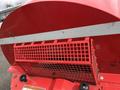 Close-up of a red grid cover on a John Deere 1585 Terrain Cut mower with a horizontal silver stripe and various vents and buttons visible