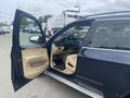 A 2009 BMW X5 with an open driver’s door and a light beige interior visible from the driver's seat