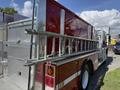 A 1994 Volvo FE 42 fire truck with a shiny red and silver body featuring a ladder rack and storage compartments on the sides