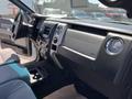 Interior view of a 2014 Ford F-150 showing the dashboard with controls and a stereo system along with seating and a central console