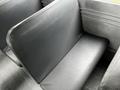 A black leather seat from a 2015 Spartan school bus with a smooth textured surface and a curved backrest