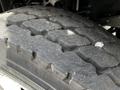 A close-up of a heavy-duty tire with deep, textured treads designed for durability and traction