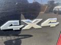 Close-up of a metallic "4X4" badge on a 2011 RAM 1500 truck