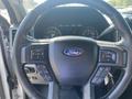 Steering wheel of a 2017 Ford F-150 with control buttons and the Ford logo in the center