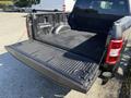 A 2018 Ford F-150 with the tailgate down and a lined truck bed showcasing its spacious cargo area