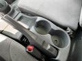 The image shows the armrest and cup holders of a 2016 Isuzu NQR vehicle interior with a gray fabric seating surface.