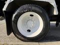 Close-up of a white truck wheel with a black tire labeled ARISUN the wheel features multiple bolt holes and is mounted on a silver rim