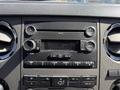 Dashboard of a 2012 Ford F-350 SD showing audio controls and display with buttons for volume tuning and media options