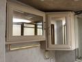 A set of mirrored cabinets with a gold towel rack underneath in a bathroom setting of a 2000 Ford Motorhome