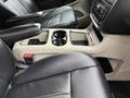 Interior view of a 2017 Dodge Grand Caravan showing leather seats and a center console with cupholders and storage compartments