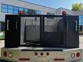 A 2008 Ford F-550 truck with an open rear compartment featuring a metal mesh gate on each side and red lights mounted on the top