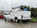 A white 2024 RAM 5500 service truck with a mounted crane and tool compartments on the back