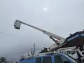 A 2006 Ford Econoline van with a raised bucket lift extending from its roof