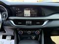Interior dashboard of a 2020 Alfa Romeo Stelvio featuring a touchscreen display audio system and climate control knobs