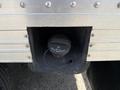 Close-up of a fuel tank opening cover on a 2023 Ford E-450 with a black cap and tether attached to the vehicle's body